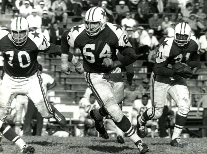 Roughneck footballer James Ray Smith blocks for a Dallas Cowboys running back.